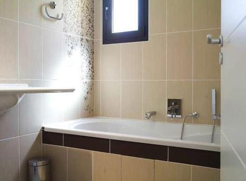 y baño con bañera y ventana. en Résidence A Rundinella en Porto Vecchio