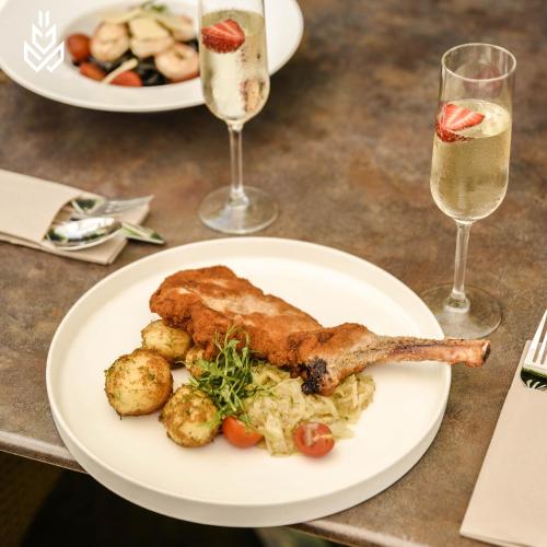 a plate of food on a table with glasses of champagne at Dwór w Tomaszowicach in Modlnica