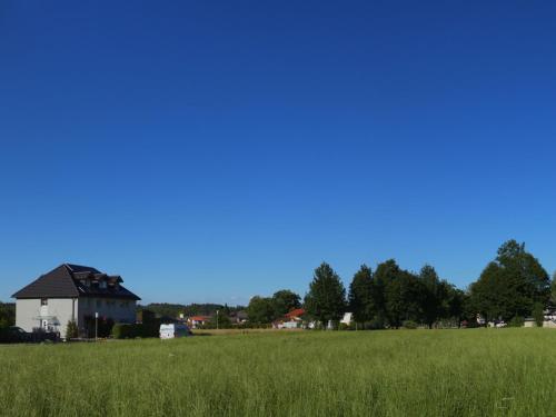 a field of green grass with a house in the background at Gästehaus Marzoll in Bad Reichenhall