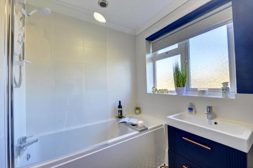 a white bathroom with a tub and a sink at Inspire Homes 2-Bed Sleeps 5 near Leamington & M40 in Southam