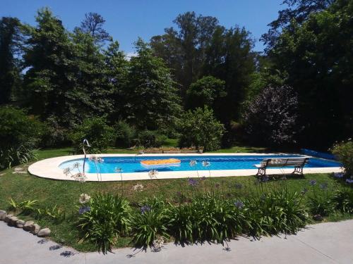 a swimming pool with a bench in a park at Casa Cuatro Robles in Mar del Plata