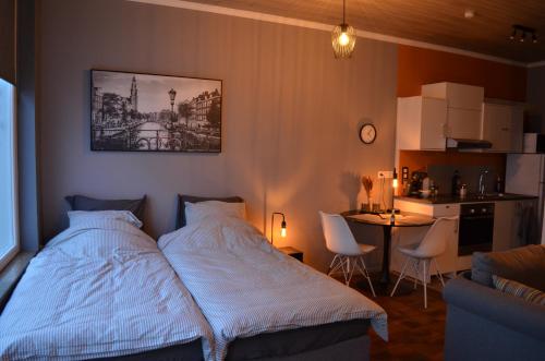 a bedroom with a bed and a table and a kitchen at Chez Henri in Stavelot