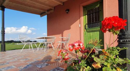 a patio with chairs and a table and a green door at Campo dei Miracoli in Villa Lía