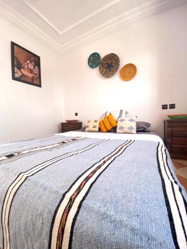 a bedroom with a large bed with a blue blanket at Tamraght White Hostel in Tamraght Ouzdar