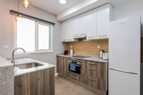 a kitchen with white cabinets and a sink at 3 Bdr&terrace Close To Subway in Hospitalet de Llobregat