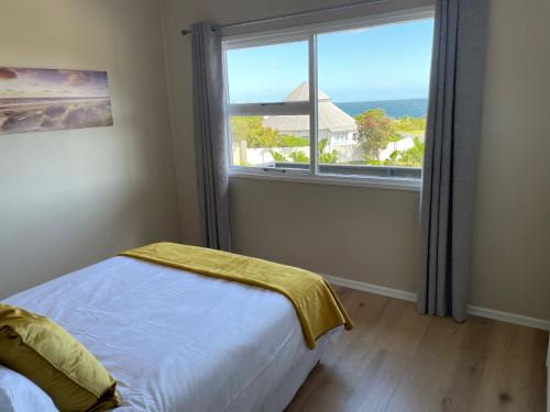 a bedroom with a bed and a large window at 2 on Third Avenue in Hermanus