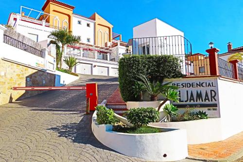 una fila de edificios con macetas en una calle en ALJAMAR 3B ( 4 Pax ), en Nerja