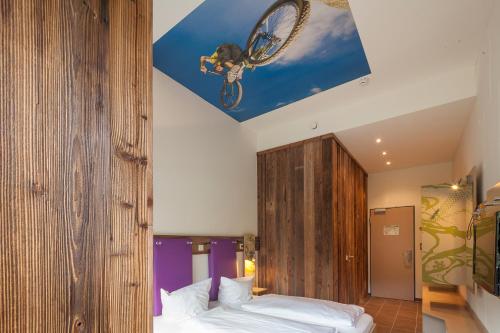 a bedroom with two beds and a bike on the ceiling at Explorer Hotel Bad Kleinkirchheim in Bad Kleinkirchheim