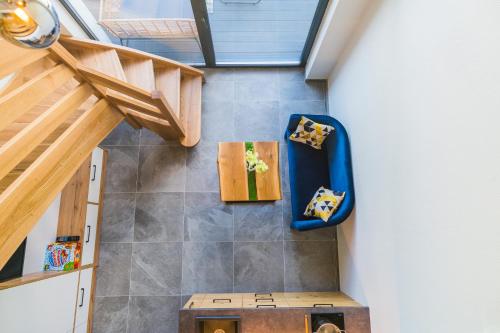 een zolderkamer met een trap en een blauwe stoel bij Aparthotel Pod Stokiem z sauną i jacuzzi - Dream Apart in Szczyrk