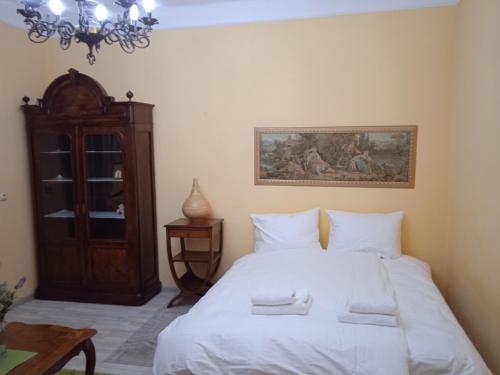 a bedroom with a bed with white sheets and a chandelier at Bajloni lux in Belgrade