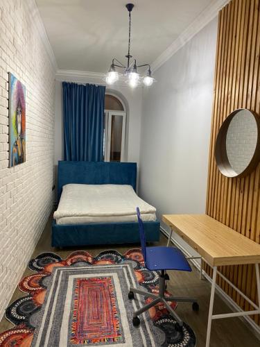 a bedroom with a bed and a desk and a table at Apartment na Kirova 37 in Pyatigorsk