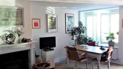een woonkamer met een eettafel en een televisie bij 38 Newtown in Bradford on Avon