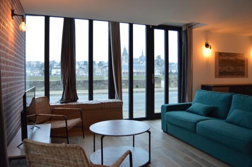 un soggiorno con divano, tavolo e sedie di "Gîte Le Relais Viennois" vue sur Loire & linge inclus a Blois