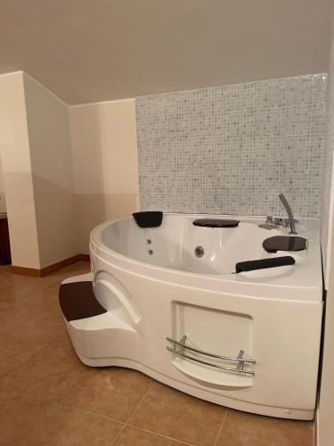 a white bath tub sitting in a room at Baita Fiorita in Mongiuffi Melia
