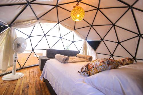 a room with a bed in a triangular shaped room at La Cabaña Glamping Geronimo in Playa Blanca