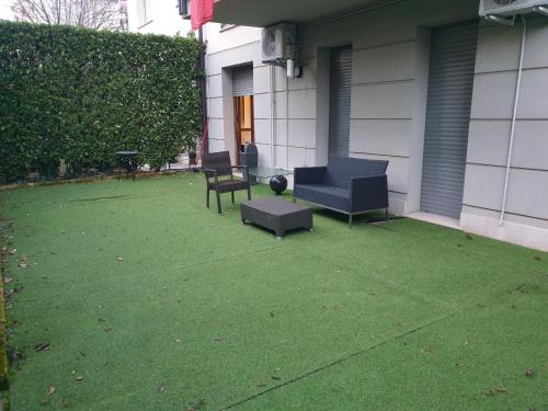 a patio with two chairs and a table on a yard at Apartment Airport in Bergamo