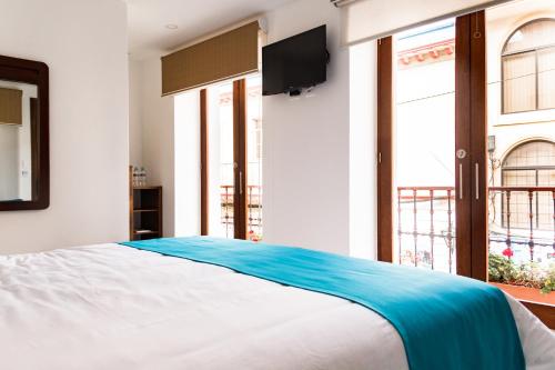 a bedroom with a large bed with a tv on the wall at REEC Latacunga by Oro Verde Hotels in Latacunga