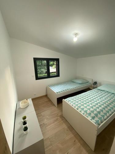 une chambre avec deux lits et une table dans l'établissement Villa Chantaco Bassin Arcachon, à Gujan-Mestras