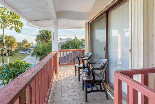 a balcony with chairs and a table on a porch at PERFECT BEACH GETAWAY for 6-10 in Satellite Beach