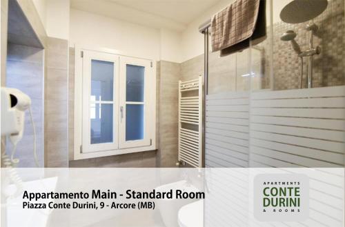 a bathroom with a shower and a glass door at Conte Durini Apartments & Rooms in Arcore