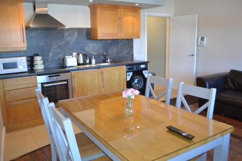 a kitchen with a table with a vase of flowers on it at Walsh's Hotel and Apartments in Maghera