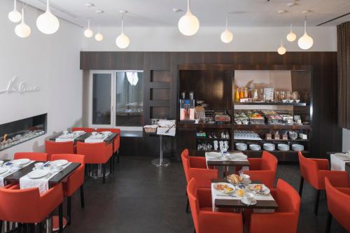 un restaurante con mesas y sillas rojas y una barra en Alma Boutique-Hotel, en Viena