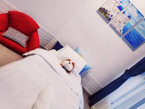 a teddy bear sitting on top of a bed at ATLANTIS@MELAKA BY SWEETSTAY in Melaka