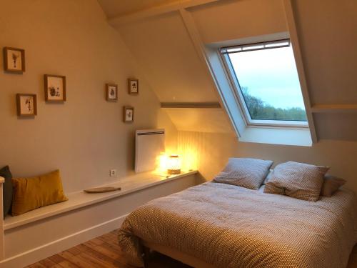 - une chambre avec un lit et une fenêtre au-dessus dans l'établissement La Roseaulière, à Bazinghen