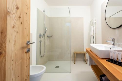 a bathroom with a shower and a sink at Hotel Tyrol in Funes