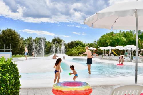 un grupo de niños jugando en la piscina de un complejo en Isaresidence Holiday Resort en Ca Lino