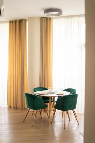 a dining room with a table and green chairs at Apartment in Druskininkai City Centre in Druskininkai