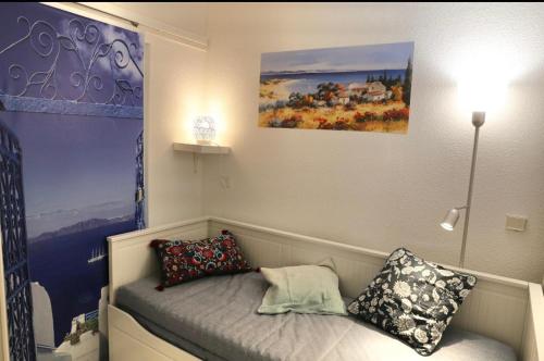 um quarto com uma cama com almofadas e um quadro em Azzurra em Beausoleil