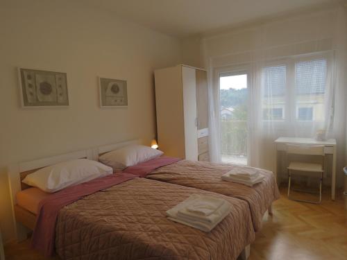 1 dormitorio con 1 cama con 2 toallas en Sani Apartments, en Začretje