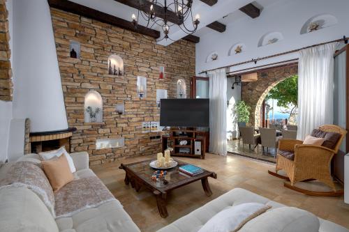 a living room with a couch and a tv at Villa Haraki Paradise in Haraki