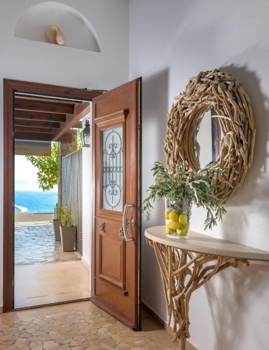 a room with a table and a mirror next to a door at Villa Haraki Paradise in Haraki