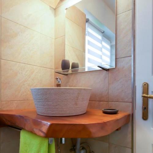 une salle de bain avec un lavabo et un miroir dans l'établissement COTTAGE-GITE COEUR DE SUNDGAU, à Leymen