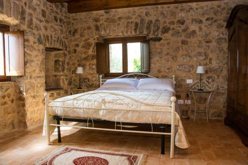 1 dormitorio con 1 cama en una pared de piedra en Agriturismo Casale Ré, en Sonnino