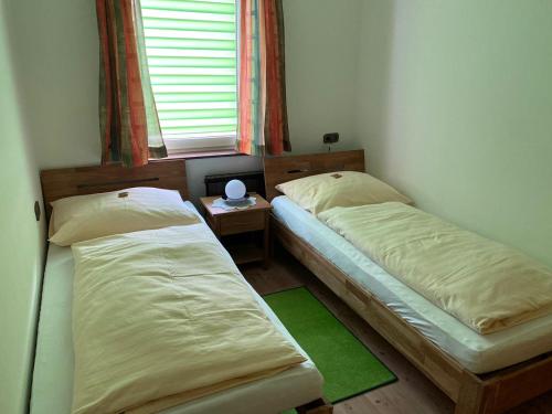 two twin beds in a room with a window at Hotel - Pension Scheiblechner in Göstling an der Ybbs