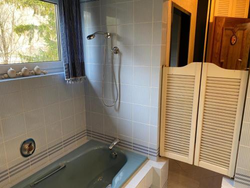 a bathroom with a blue tub and a window at Hotel - Pension Scheiblechner in Göstling an der Ybbs