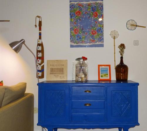 a blue dresser in a room with a lamp and a guitar at CASA DO TANQUE AMARELO by Stay in Alentejo in Vila Nova de Milfontes