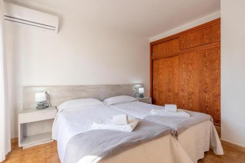 a bedroom with a large bed with two towels on it at BRESSOL DELUXE Apartments in Port de Pollensa
