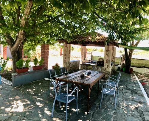 a wooden table and chairs under a gazebo at Blue Garden Inn in Fourka