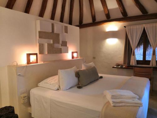 a bedroom with a bed and a laptop on the bed at Tierra del Mar Hotel - Adults Only in Holbox Island