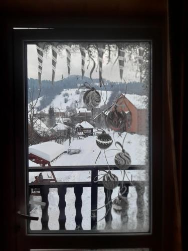 a window with a view of a snow covered yard at Між Тростяном та рікою in Slavske