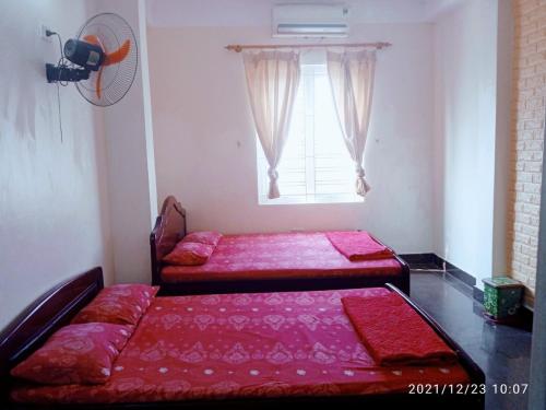 a bedroom with two beds and a window at Nhà Nghỉ Hải Yến in Tinh Xa