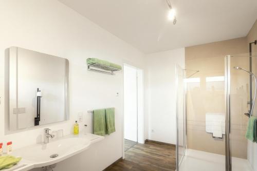 a white bathroom with a sink and a shower at Ferienwohnung Bergäcker in Neualbenreuth
