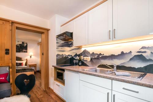 una cucina con mobili bianchi e un lavandino di Wohlfühl-Ferienwohnungen Schneider a Bad Hindelang
