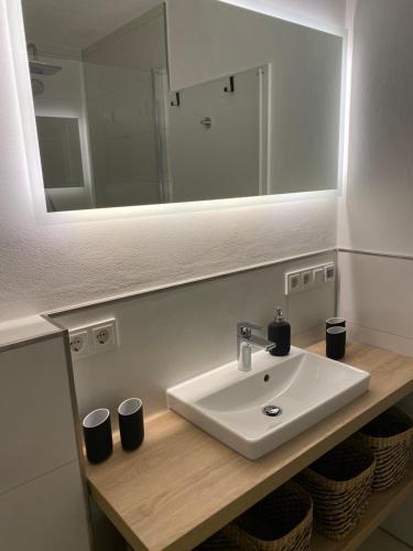 La salle de bains est pourvue d'un lavabo et d'un miroir. dans l'établissement Petine Langeoog, à Langeoog