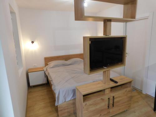 um pequeno quarto com uma televisão num suporte de madeira em Apartments J&M em Ohrid
