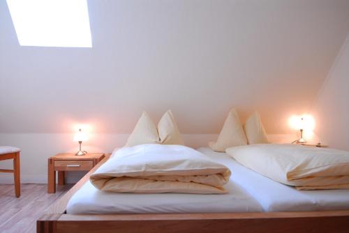 a bedroom with two beds with white sheets and lamps at Ferienwohnung Mare Nostrum 11 in Westerland